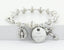 Crystal lined pearl rosary bracelet with an engraved disc and charms.