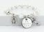 White pearl and crystal rosary bracelet with an engraved disc and charms.