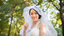 Bride with veil on sunny day with trees in the background. 