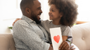 Daughter and father hugging while father holds a card with a heart.