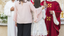 A mother and daughter standing in front of two catholic priests.