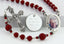 Red memorial rosary beads with photo centerpiece and engraved disc.