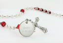 White pearl and red crystal rosary with an engraved disc and name in beads.