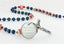 Custom dark blue first communion rosary with red baseballs, an engraved disc, and a name in beads.