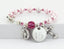 Pink pearl and crystal rosary bracelet with an engraved disc and charms.