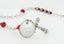 White first communion rosary with red crystals and an engraved disc, for a boy’s communion gift.