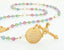 Custom gold rosary with multiple color birthstones and an engraved disc.