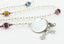 White pearl and multiple color birthstone family rosary with an engraved disc. 